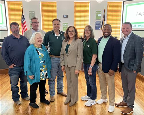 McCutchen named lone finalist for Superintendent of Schools group of 8 adults in front of 4 windows